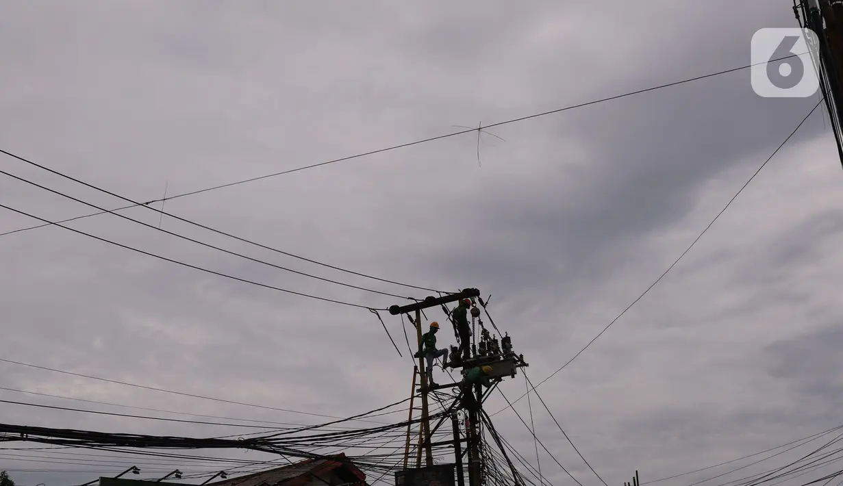 Petugas melakukan maintenence trapo listrik di Kota Tangerang, Banten, Jumat (26/11/2021). Pemerintah mau mendorong investasi baru terutama industri supaya konsumsi listrik bisa mengimbangi. (Liputan6. com/Angga Yuniar)
