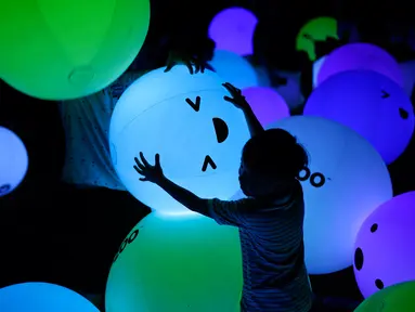 Siluet seorang anak yang sedang bermain balon berbagai warna saat festival Light Marina Bay di Singapura (8/3). Seni instalasi ini dirancang dengan pencahayaan ramah lingkungan yang hemat energi. (AP Photo / Wong Maye-E)