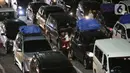 <p>Seorang pria sambil menggendong anak melintas di antara mobil pribadi yang akan menyeberang ke Pulau Sumatera terjebak kemacetan sebelum masuk ke kapal "Roll on-Roll off" (RoRo) di Pelabuhan Merak, Banten, Kamis (28/4/2022). Jelang hari raya Idul Fitri, pemudik dengan kendaraan bermotor mulai memadati Pelabuhan Merak. Penumpukan kendaraan ini menyebabkan terjadinya antrean kendaraan yang panjang. (Liputan6.com/Angga Yuniar)</p>