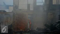 Petugas pemadam kebakaran berusaha memadamkan api yang membakar pemukiman di kawasan padat penduduk Bukit Duri, Jakarta, Selasa (23/2). Hingga kini penyebab kebakaran masih dalam penyelidikan pihak terkait. (Liputan6.com/Gempur M Surya)