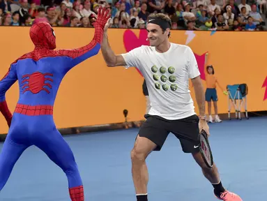 Petenis Swiss Roger Federer (kanan) bertepuk tangan dengan Spider-Man selama Hari Anak-anak menjelang turnamen tenis Australia Terbuka di Melbourne (13/1). (AFP Photo/Paul Crock)