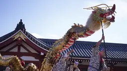 Penduduk setempat memainkan "Kinryu no Mai," atau Tarian Naga Emas di Kuil Sensoji di lingkungan Asakusa di Tokyo, Senin (18/10/2021). Naga Jepang  adalah makhluk legendaris yang beragam dalam mitologi dan cerita rakyat Jepang.(AP Photo/Eugene Hoshiko)