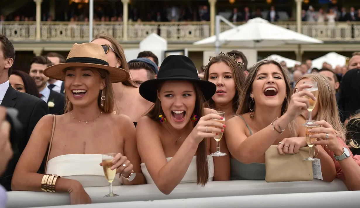 Sejumlah wanita bersorak saat menyaksikan pacuan kuda Everest 2017 di Royal Randwick di Sydney, Australia (14/10). Para wanita ini tampil cantik dengan busana yang dikenakannya . (AFP Photo/Peter Parks)