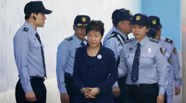 Mantan Presiden Korsel Park Geun-hye dengan tangan diborgol tiba di Pengadilan Distrik Pusat Seoul, Korea Selatan (23/5). Park Geun-hye menjalani sidang perdana atas serangkaian tuduhan korupsi yang dialamatkan kepadanya. (Kim Hong-ji/Pool Photo via AP)