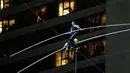 Aerialists Nik Wallenda (atas) melangkahi saudara perempuannya Lijana Wallenda saat melintasi seutas kawat di ketinggian 396 meter, Times Square, New York, AS, Minggu (23/6/2019). Nik dan Lijana berjalan dari sisi berbeda yang digantung di antara dua menara Times Square. (AP Photo/Jason Szenes)