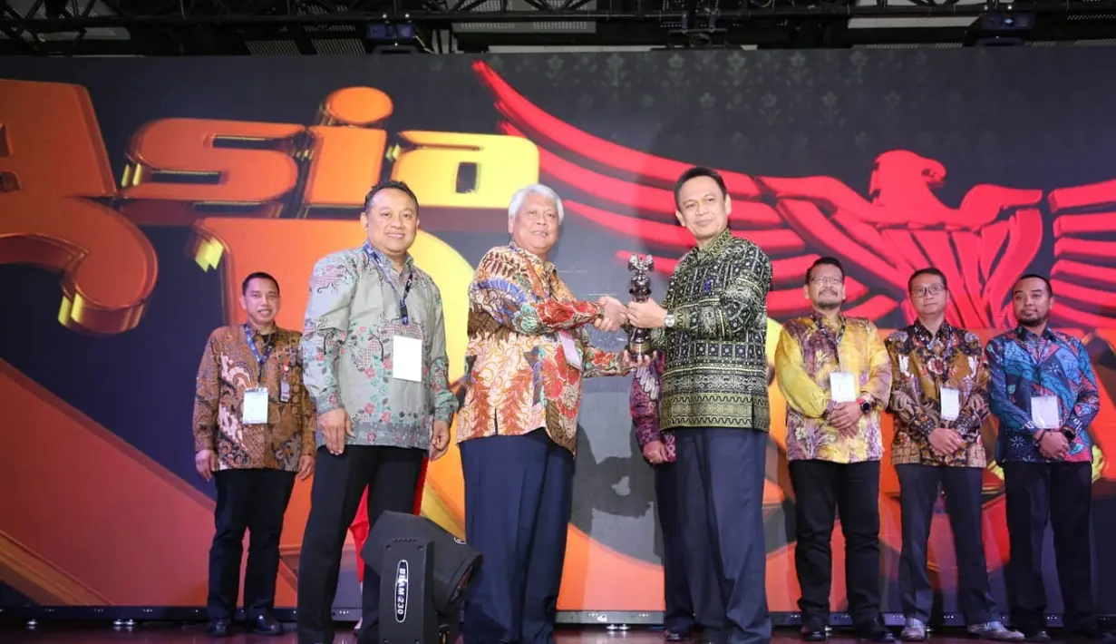 Direktur Transformasi Bisnis PT Pupuk Indonesia Nugroho Christijanto (tengah) mendapatkan penghargaan SRA 2018 Asisten II Setprov Lampung Taufik Hidayat (kanan) dalam acara The 14th SRA di Lampung, Sabtu (8/12). (Liputan6.com/HO/Ines)