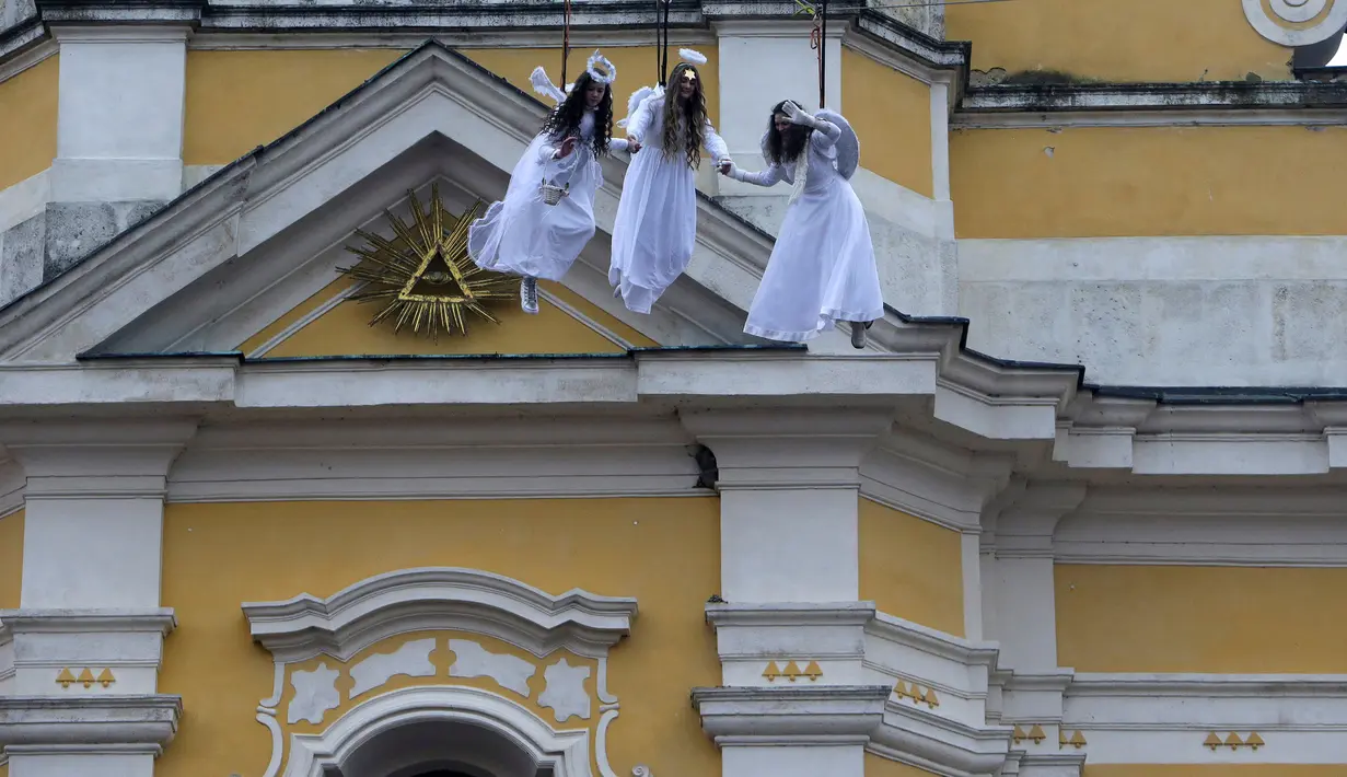 Sejumlah wanita berpakaian seperti malaikat melambakaikan tangan kearah pengunjung saat berayun di acara pasar Natal di kota Ustek, Republik Ceko (17/12). Mereka melakukan aksi ini dalam rangka untuk menyambut datangnya natal. (Reuters/David W Cerny)