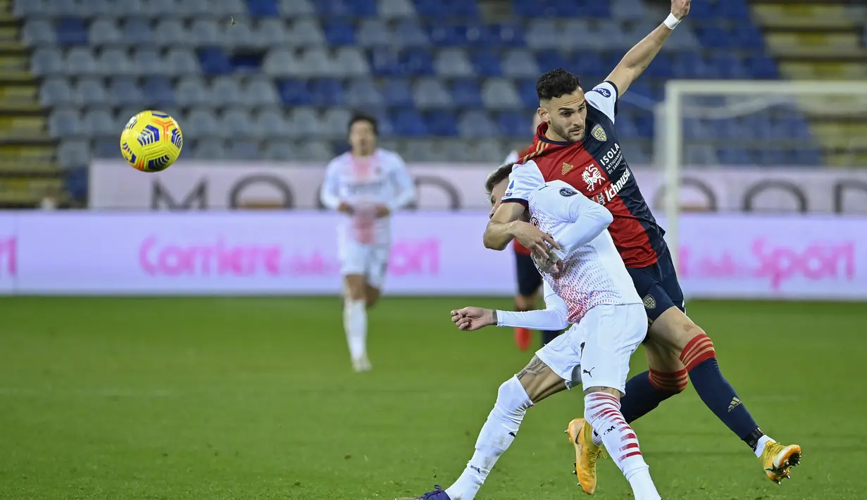 Bek Cagliari, Charis Lykogiannis (kanan) bertabrakan dengan pemain depan AC Milan Samuel Castillejo pada pertandingan Liga Serie A Italia di Sardegna Arena, Selasa (19/1/2021). AC Milan unggul tiga angka dari Inter Milan yang ada di urutan kedua.  (AFP/Alberto Pizzoli)