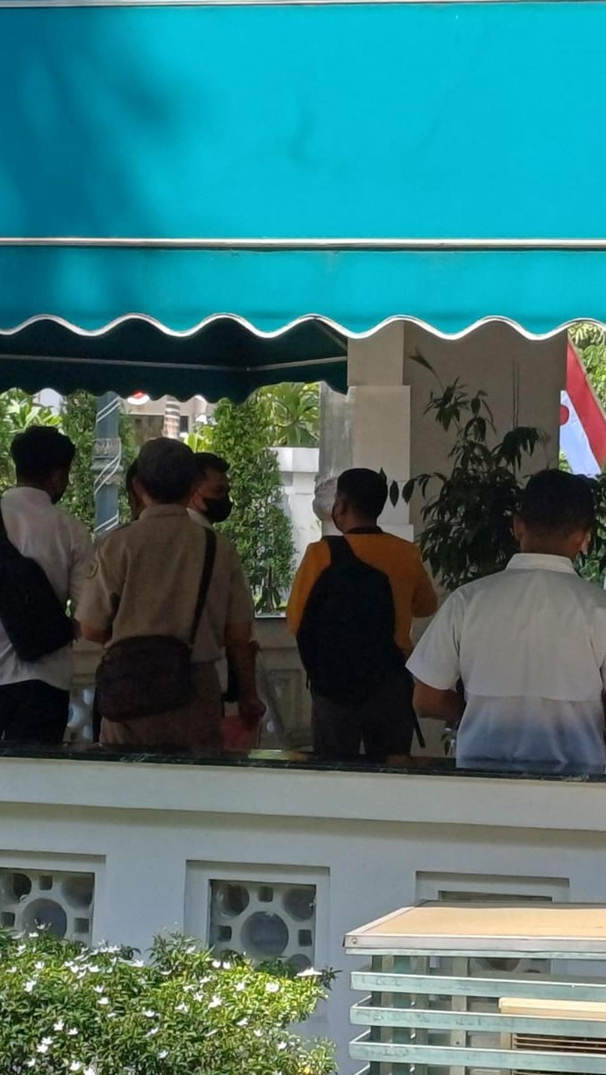 Terlihat juga personel Ditreskrimsus Polda Jatim dari ruang lobi utama berpintu kaca. Jumlahnya lebih banyak dari anggota yang duduk di lorong bangunan sisi luar.