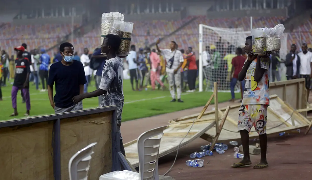Polisi menembakkan gas air mata untuk mengejar penyerbu lapangan pada akhir pertandingan kualifikasi Piala Dunia 2022 antara Ghana Vs Nigeria di Stadion Moshood Abiola, Abuja, Nigeria, 29 Maret 2022. Fans Nigeria ngamuk setelah gagal lolos ke Piala Dunia 2022. (AP Photo/Sunday Alamba)
