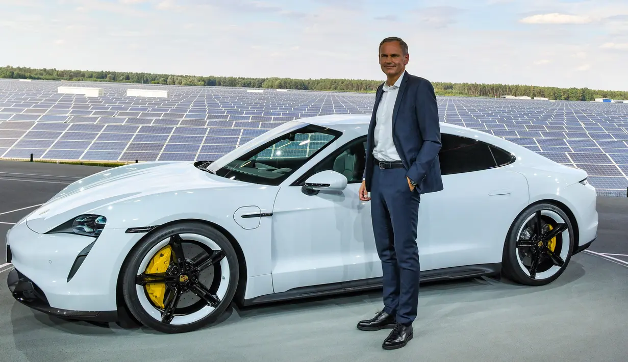 CEO Porsche, Oliver Blume, berdiri di sebelah mobil elektrik Porsche, Taycan selama world premiere di bandara Neuhardenberg, dekat Berlin, Rabu (4/9/2019). Mobil listrik dengan model Saloon Sport 4 pintu itu disebut menawarkan ketangguhan namun bisa dipakai sehari-hari. (Patrick Pleul/dpa via AP)
