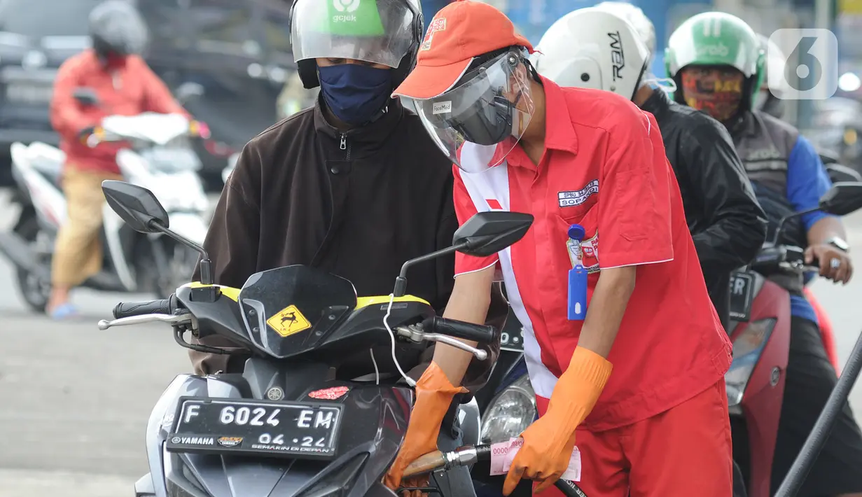 Petugas dengan sarung tangan, masker dan pelindung wajah melayani pembeli BBM di SPBU kawasan Cilendek, Bogor, Selasa (5/5/2020). Mencegah penularan Covid-19, sejumlah perusahaan memberikan pelindung diri kepada pegawai, terlebih yang berhubungan langsung dengan pelanggan. (merdeka.com/Arie Basuki)