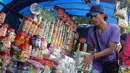 Pedagang menata kue kaleng di kios penjual kue kering musiman di kawasan Ciracas, Jakarta, Minggu (12/7). Sejak beberapa hari terakhir, transaksi pedagang musiman kue kering mengalami peningkatan jelang hari raya Idul Fitri. (Liputan6.com/Helmi Afandi)