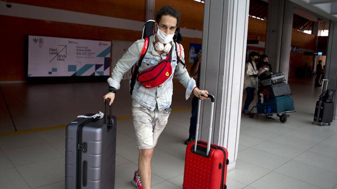<p>Seorang turis Rusia tiba di Bandara Internasional Bali, Jumat (4/2/2022). Bali kembali dibuka untuk pelancong asing dari semua negara setelah penerbangan internasional dilanjutkan untuk pertama kalinya dalam dua tahun, tapi pengunjung tetap wajib karantina. (AP Photo/Firdia Lisnawati)</p>