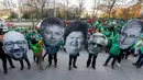Demonstran mengenakan topeng yang menggambarkan Perdana Menteri Belgia Charles Michel (kiri), Sosial dan Menteri Kesehatan Maggie De Block (tengah) dan politisi lainnya di Belgia, Brussels, Kamis (24/11). (REUTERS / Yves Herman)
