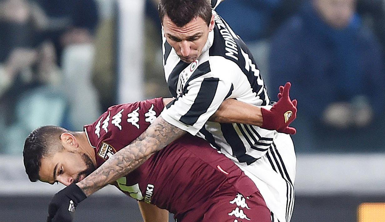 Pemain Juventus, Mario Mandzukic (kanan) berebut bola dengan pemain Torino, Tomas Rincon pada laga perempatfinal Coppa Italia di Allianz Stadium, Turin, Italia, (3/1/2018). Juventus menang 2-0. (Alessandro Di Marco/ANSA via AP)