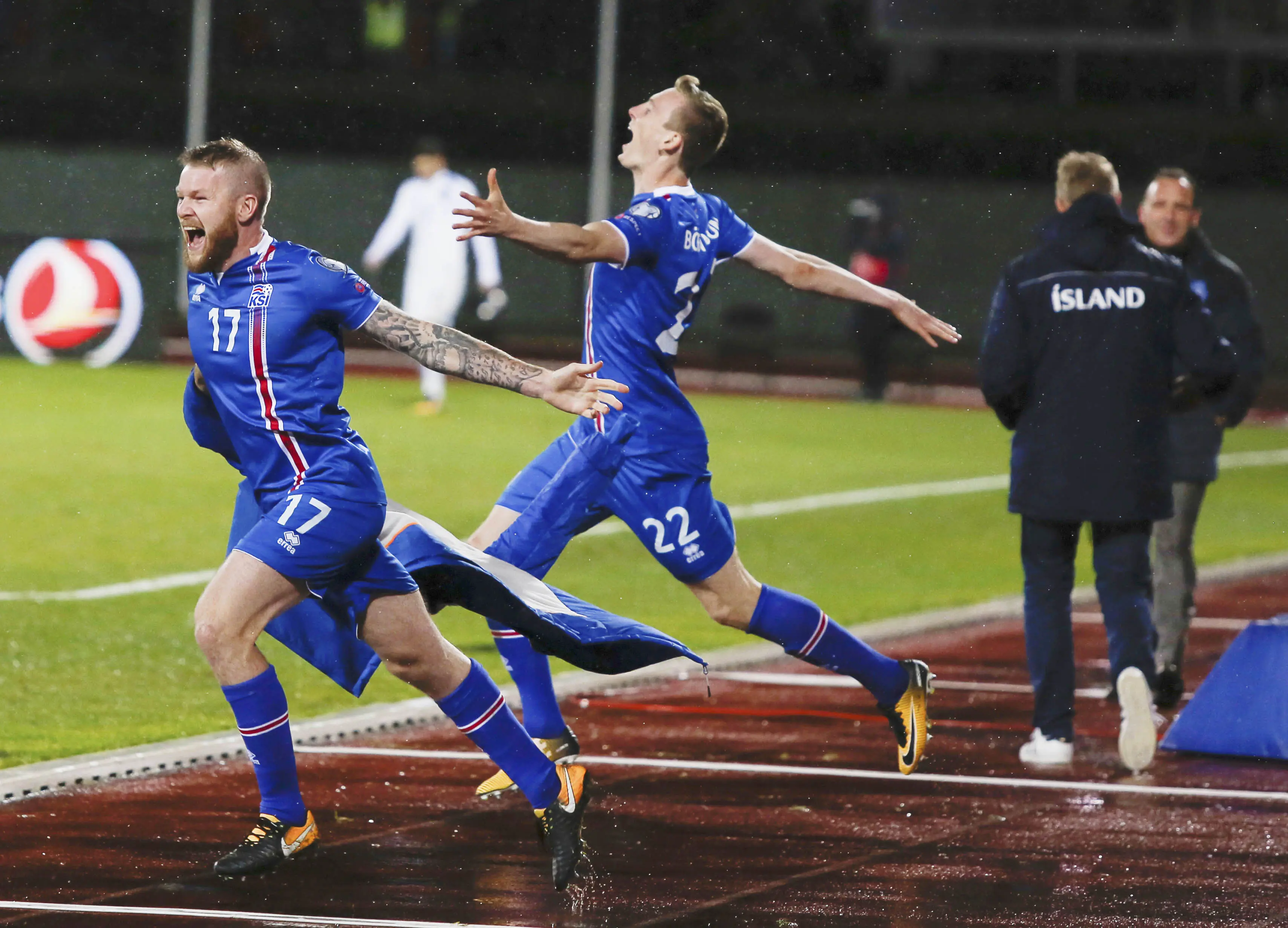 Pemain Islandia, Aron Einar Gunnarsson dan Jon Dadi Bodvarsson melakukan selebrasi usai memastikan negaranya lolos Piala Dunia 2018 di Stadion Laugardalsvöllur, Senin (9/10/2017). Islandia menang 2-0 atas Kosovo. (AP/Brynjar Gunnarsson)
