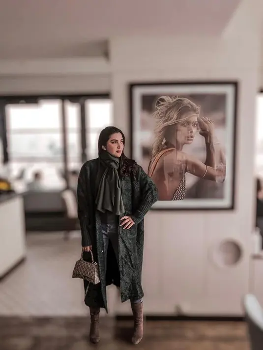 Kali ini, Ashanty tampil lebih bold busana nuansa warna army. Mulai dari coat dan syal. Untuk sepatu, ia memilih boots cokelat. (Instagram/ashanty_ash).