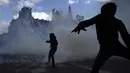 <p>Bentrokan tak terhindari, di mana polisi menggunakan bom asap, proyektil, dan gas air mata dalam aksi di Dewan Konstitusi. Kekerasan juga pecah di Place de la Bastille. (AP Photo/Lewis Joly)</p>