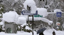 Orang-orang berjalan di atas salju yang menumpuk di kota Toyama, di pesisir Laut Jepang, Senin (11/1/2021). Sedikitnya delapan orang tewas dan sekitar 240 lainnya luka-luka saat badai musim dingin yang kuat melanda daerah pesisir di sepanjang Laut Jepang. (Kyodo News via AP)