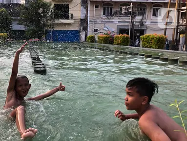 Anak-anak berenang di kolam penghias taman Pasar Baru di Jakarta, Rabu (2/9/2020). Meskipun terdapat larangan, namun sejumlah anak tetap nekat berenang di kolam tersebut sehingga mengganggu ketertiban umum. (Liputan6.com/Immanuel Antonius)