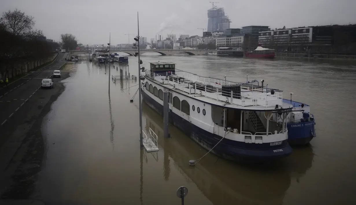 Sebuah kapal bersandar saat sungai Seine meluap di Paris, Senin (8/2/2021).  Luapan sungai Seine hampir menenggelamkan beberapa taman dan alun-alun di sepanjang tepiannya. (AP Photo/Thibault Camus)