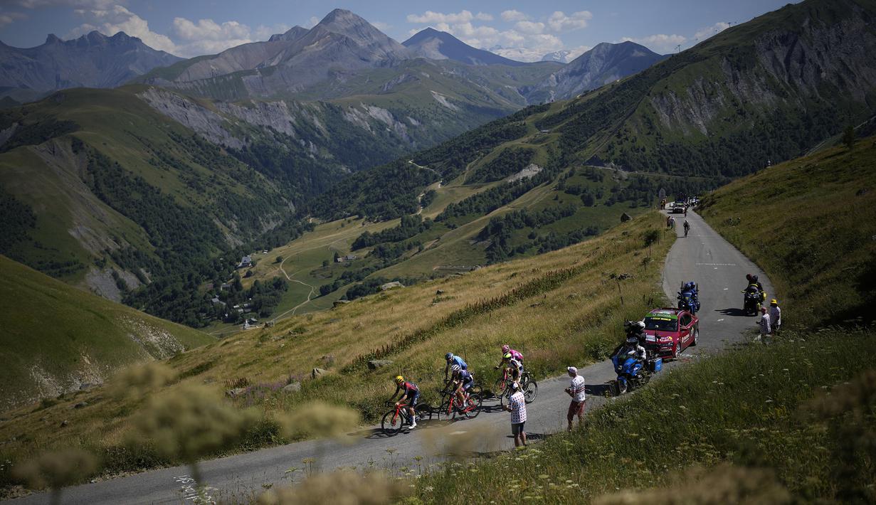 Pebalap tim Ineos Grenadiers, Thomas Pidcock (kiri) memimpin rombongan saat Stage 12 Tour de France 2022 yang menempuh rute sepanjang 165,1 km dari Briancon hingga L'Alpe-d'Huez, di Pegunungan Alpen, Prancis, Jumat (14/07/2022). (AP/Thibault Camus)