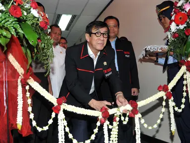 Menkumham Yasonna Laoly menggunting pita meresmikan tim Pengawasan Orang Asing  (PORA) di Gedung Imigrasi Kemenkumham, Jakarta (8/4). Dalam rangka menghadapi Masyarakat Ekonomi Asia (MEA) Menkumham meresmikan ruang timpora . (Liputan.com/Helmi Afandi)