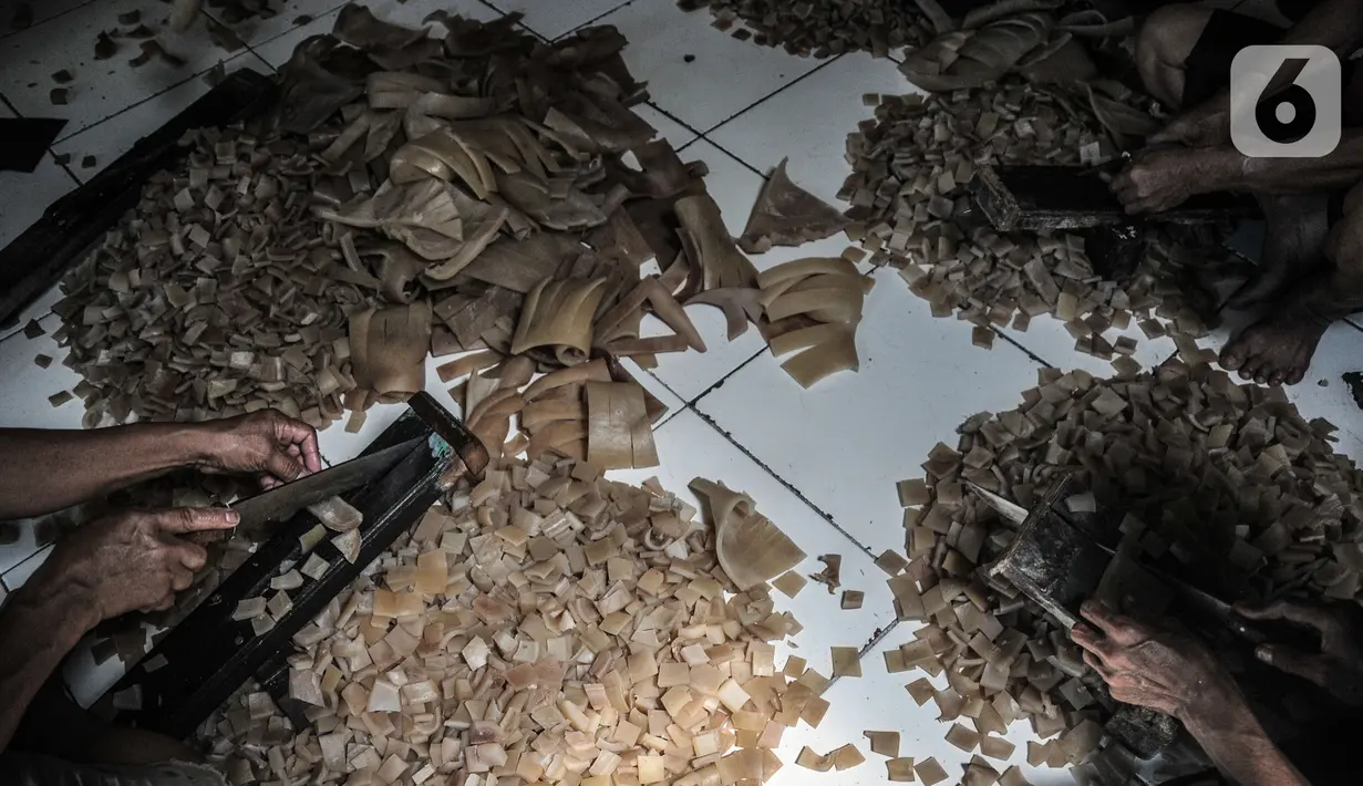 Pekerja menyelesaikan pembuatan kerupuk kulit di industri rumahan kawasan Bogor, Minggu (26/9/2021). Sebelum Covid-19 melanda biasanya pelaku usaha kerupuk kulit mampu memproduksi 30 lembar kulit sapi dalam sehari, namun kini hanya 12-15 lembar kulit per hari. (merdeka.com/Iqbal S Nugroho)