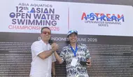 Executive Director Asia Aquatics Farid Fattahian (kanan) saat memberikan medali kepada Ketua Harian PB Akuatik Indonesia Harlin E. Rahardjo saat 12th Asian Open Water Swimming Championship 2026 di Pantai Jimbaran pada Minggu (14/6/2026). (Bola.com/Alit Binawan)