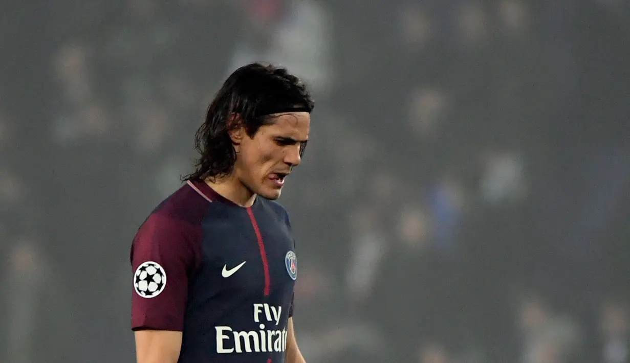 Pemain Paris Saint-Germain (PSG), Edinson Cavani menunduk setelah timnya kalah melawan Real Madrid pada babak 16 besar Liga Champions di Stadion Parc des Princes, Paris, Prancis, Selasa (6/3). Real Madrid menang 2-1. (PIERRE-PHILIPPE MARCOU/AFP)