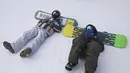 Snowboarders beristirahat di dasar lereng di resor ski Tochal di luar ibukota Teheran, Iran (1/1/2022). Di tengah polusi udara dan kesengsaraan ekonomi, penduduk Teheran menemukan kenyamanan di resor ski di utara Teheran di pegunungan Alborz. (AP Photo/Vahid Salemi)