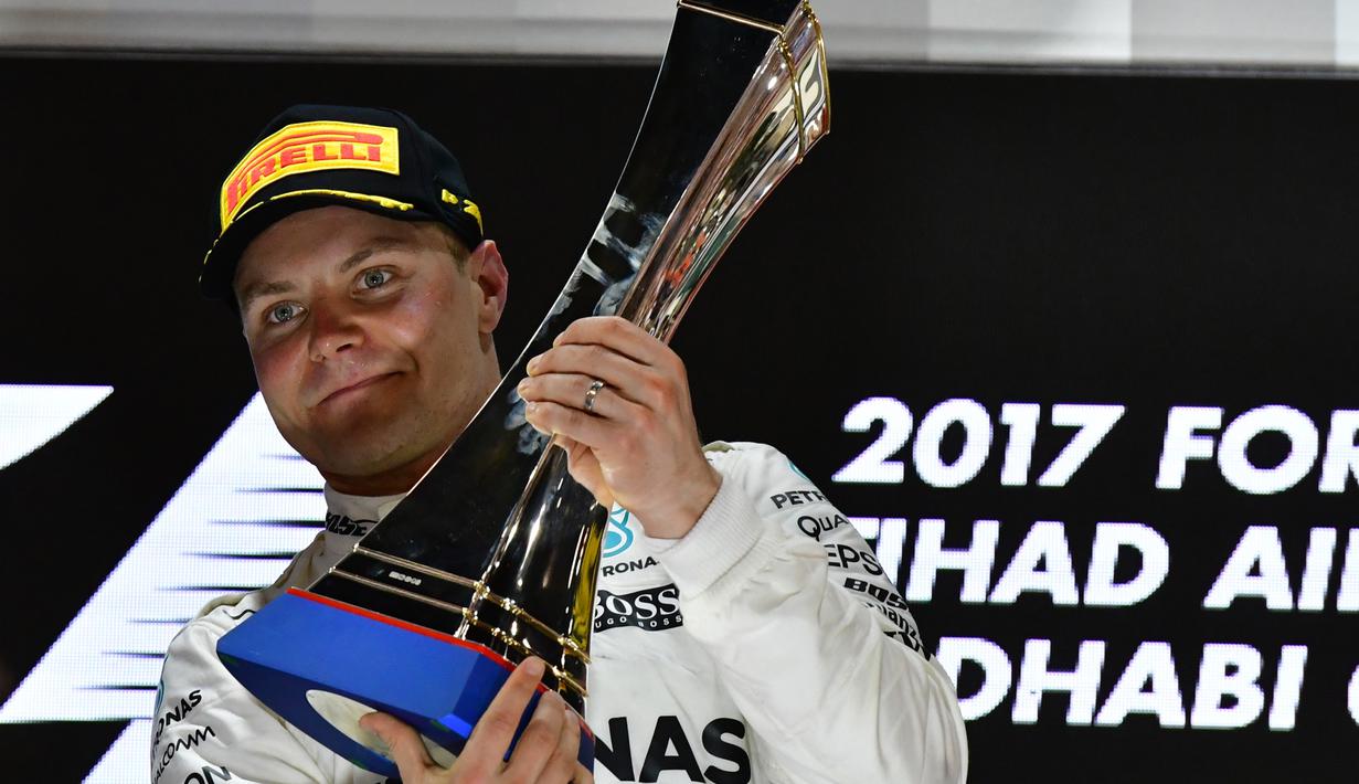 Valtteri Bottas mengangkat trofi juara seetalah finis pertama pada balapan F1 Abu Dhabi di Yas Marina circuit , (26/11/2017). (AFP/Giuseppe Cacace)