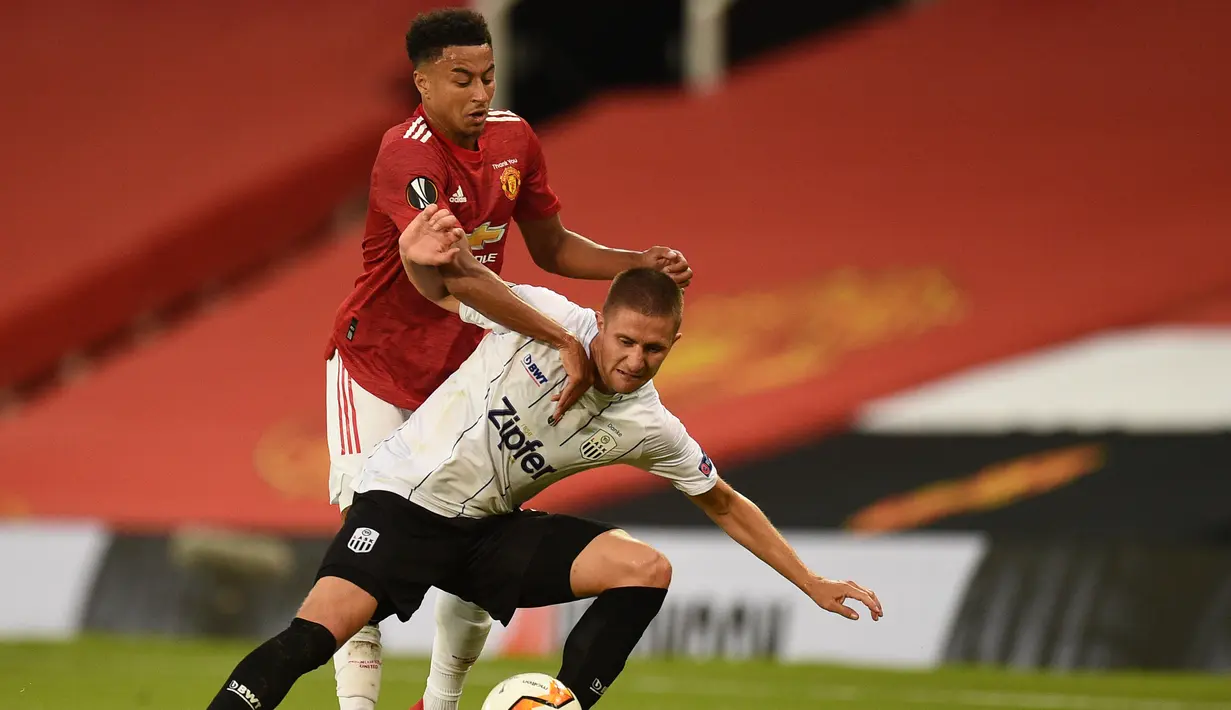 Gelandang Manchester United, Jesse Lingard, berebut bola dengan bek LASK, Reinhold Ranftl, pada laga leg kedua 16 besar Liga Europa 2019/2020 di Old Trafford, Kamis (6/8/2020) dini hari WIB. Manchester United menang agregat 7-1 atas LASK. (AFP/Oli Scarff)