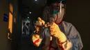 Pekerja medis berpakaian pelindung menulis pada sebuah tabung setelah mengumpulkan sampel untuk tes asam nukleat dari pasien yang diduga terinfeksi virus corona di hotel yang digunakan dalam isolasi medis virus corona di Wuhan, Provinsi Hubei, China, Selasa (4/2/2020). (Chinatopix via AP)