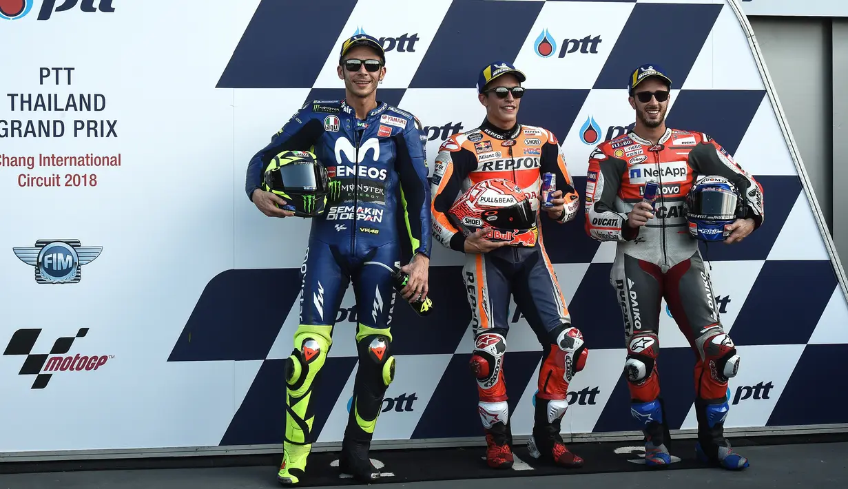 Pebalap Marc Marquez, Valentino Rossi dan Andrea Dovizioso berpose bersama usai mengikuti kualifikasi MotoGP Thailand 2018 di Sirkuit Internasional Buriram (6/10). Rossi berada di posisi kedua dengan catatan waktu 1.30.099. (AFP Photo/Lillian Suwanrmpha)