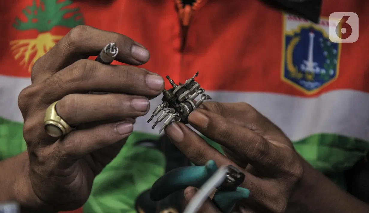 Seto Krisna Putra (39) menyelesaikan pembuatan miniatur robot dari sampah korek gas di Kantor Sudin LH Jakarta Timur, Minggu (20/2/2022). Seto menyulap sampah korek gas dari bertugas menjadi miniatur robot beragam karakter bernilai jual tinggi. (merdeka.com/Iqbal S Nugroho)