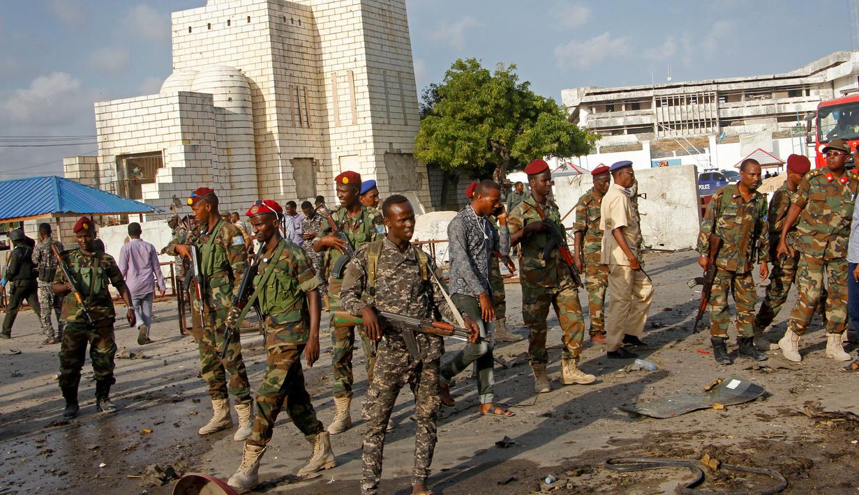 Sejumlah tentara mengamankan lokasi ledakan bom mobil yang terjadi dekat pos pemeriksaan parlemen dan Kementerian Dalam Negeri di Ibu Kota Somalia, Mogadishu, Minggu (25/3). Mobil meledak sebelum pasukan keamanan memeriksanya. (AP/Farah Abdi Warsameh)