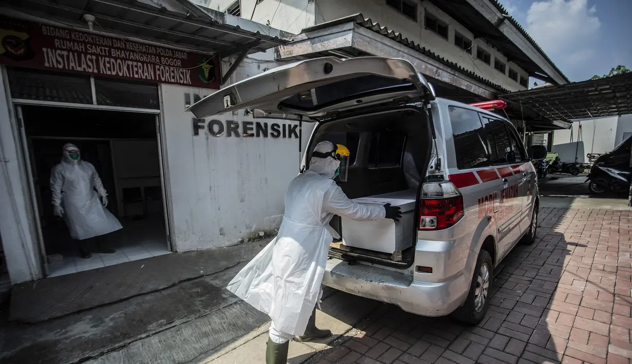 Petugas kesehatan menyiapkan peti mati berisi korban virus corona COVID-19 ke dalam ambulans di Bogor, Jawa Barat pada 3 Juli 2021. Angka kematian pasien Covid-19 saat isolasi mandiri di Indonesia sangat mengkhawatirkan di saat kasus semakin melonjak. (AFP/ Aditya Aji)