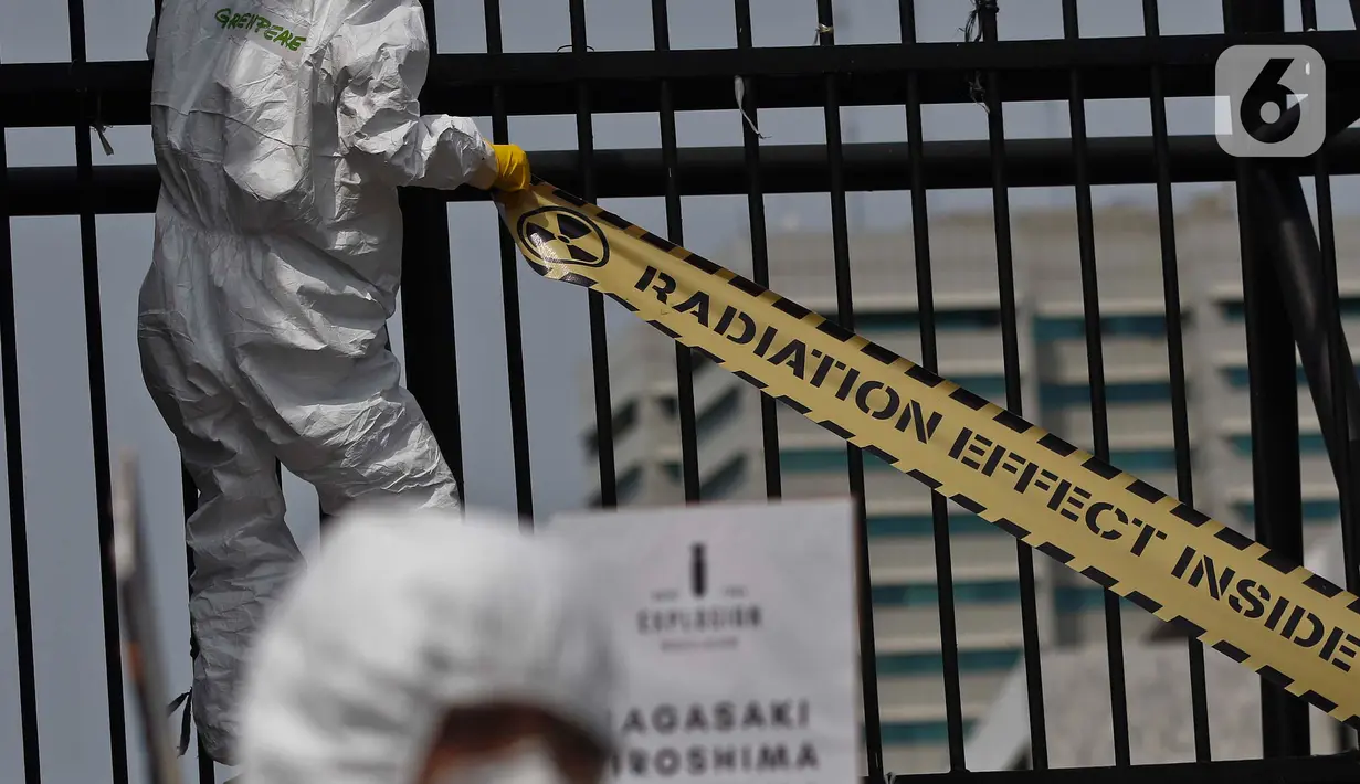 Aktivis Greenpeace menyegel pagar Gedung DPR saat menggelar aksi damai kreatif menolak energi nuklir, Jakarta, Jumat (13/3/2020). Aksi ini bagian dari peringatan sembilan tahun bencana Fukushima. (Liputan6.com/Johan Tallo)