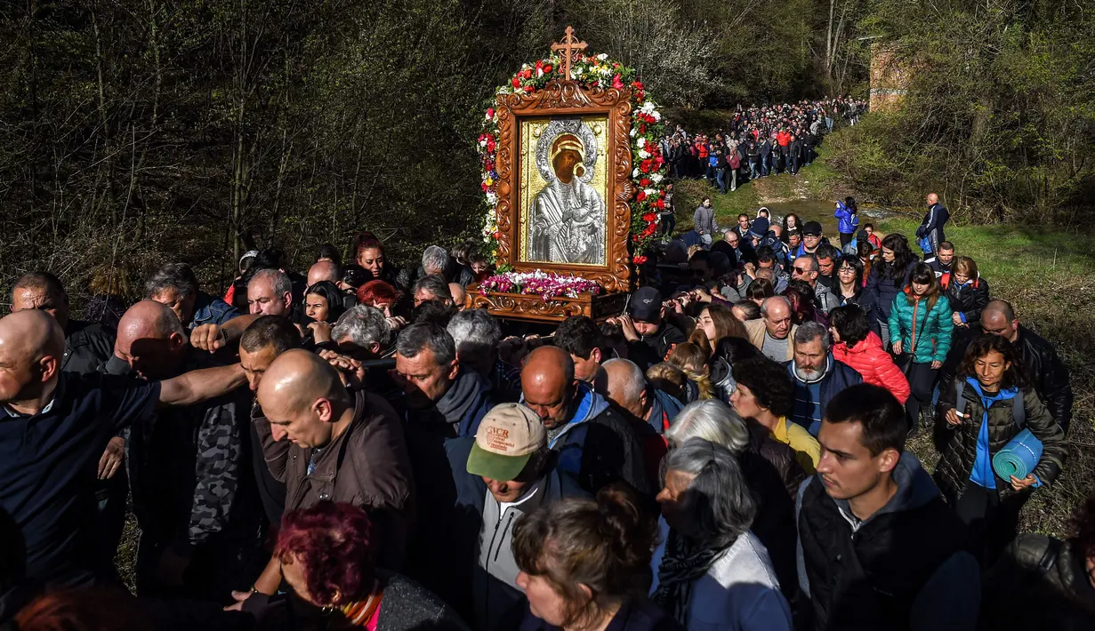 Jemaat Kristen Ortodoks membawa simbol Perawan Maria selama prosesi keagamaan tahunan di Biara Bachkovo, Bulgaria (9/4). Prosesi keagamaan yang diadakan tiap tahun ini dilaksanakan pada hari kedua Paskah Ortodoks. (AFP Photo/Nikolay Doychinov)