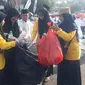 Sekelompok relawan berbaju kuning gesit membersihkan sampah di tengah kepadatan para jemaah yang menghadiri Resepsi 1 Abad NU. (NU Online)