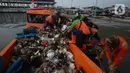 Petugas dari Dinas Lingkungan Hidup DKI Jakarta mengangkut sampah di Pelabuhan Kali Adem, Muara Angke, Jakarta, Rabu (6/1/2021). Dalam sehari, sampah pesisir Teluk Jakarta Utara bisa terangkut sekitar 7 kubik sampah plastik yang terbawa dari sungai maupun arus laut. (merdeka.com/Imam Buhori)