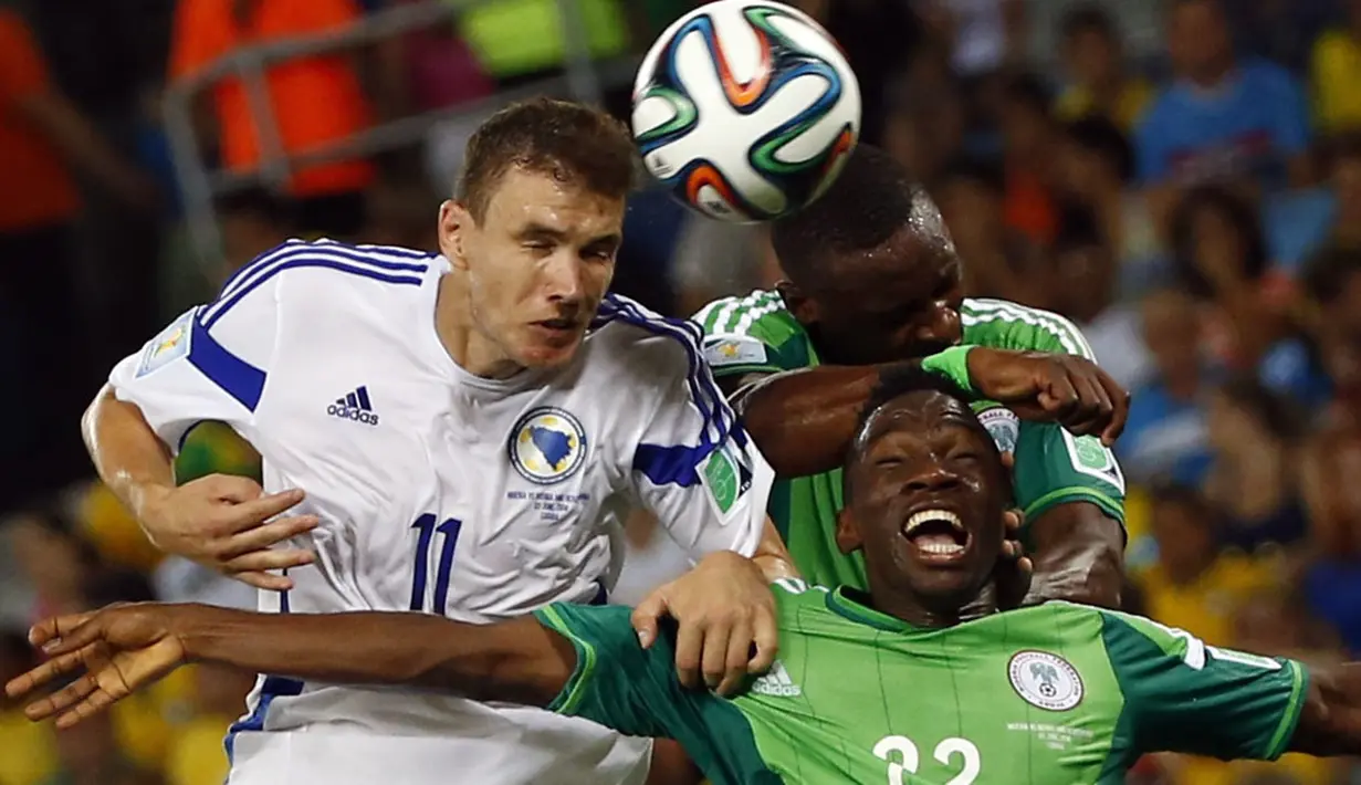 Penyerang Bosnia, Edin Dzeko (kiri) berebut bola dengan dua pemain Ghana (Kenneth Omeruo dan Shola Ameobi) saat berlaga di penyisihan Piala Dunia 2014 Grup F di Stadion Pantanal, Cuiaba, Brasil, (22/6/2014). (REUTERS/Eric Gaillard)