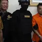 Polisi mengawal tersangka pembunuhan satu keluarga di Kota Bekasi saat gelar perkara di Polda Metro Jaya, Jakarta, Jumat (16/11). Polisi mengungkapkan tersangka HS membunuh keluarga Diperum Nainggolan seorang diri. (Merdeka.com/Imam Buhori)