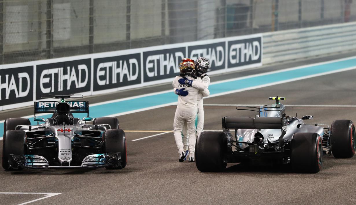 Pebalap Mercedes, Lewis Hamilton (depan) dan rekannya Valtteri Bottas merayakan keberhasilan masuk finis pada balapan F1 Abu Dhabi di Yas Marina circuit , (26/11/2017). Bottas finis pertama. (AFP/Karim Sahib)