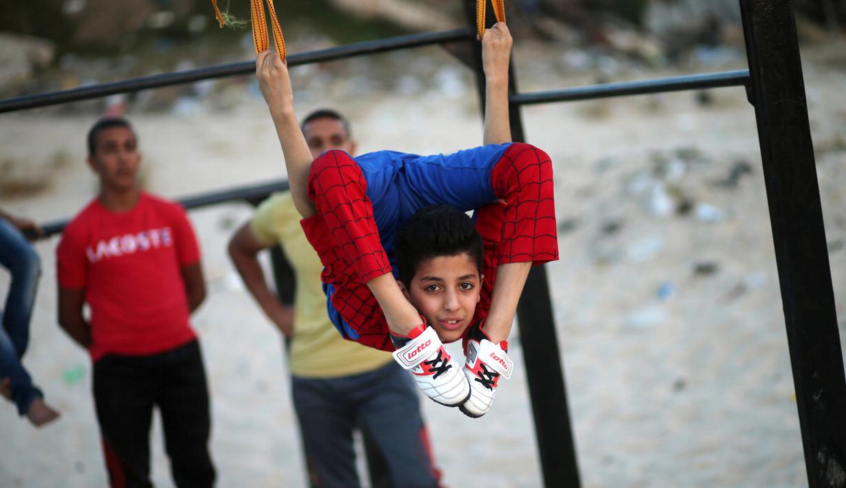 Kelenturan tubuh Mohammed al Sheikh di sebuah pantai Kota Gaza, Kamis (2/6). Dengan bimbingan pelatih khusus, ia bertekad memecahkan rekor Guinness World Record kategori melipat tubuh dengan berbagai posisi dalam waktu singkat. (REUTERS/Mohammed Salem)