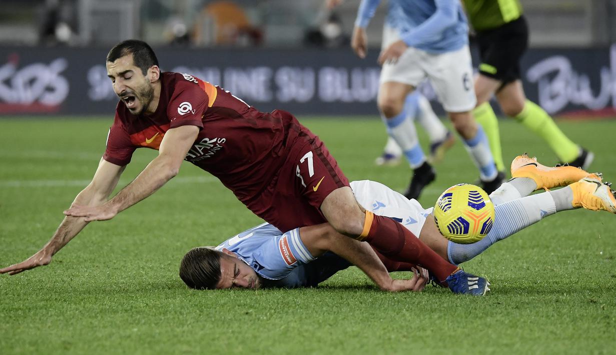 Gelandang AS Roma, Henrikh Mkhitaryan (atas) dan gelandang Lazio, Sergej Milinkovic-Savic terjatuh usai perebutan bola dalam laga lanjutan Liga Italia Serie A 2020/21 pekan ke-18 di Olympic Stadium, Roma, Jumat (15/1/2021). AS Roma kalah 0-3 dari Lazio. (AFP/Filippo Monteforte)