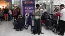Seorang penumpang bermain ponsel di deka tloket tiket Thai Airways di Bandara Internasional Suvarnabhumi di Bangkok (28/2). Hampir Ribuan penumpang tujuan Pakistan dan Eropa terjebak di bandara tersebut. (AFP Photo/Lillian Suwnrumpha)