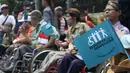 Penyandang disabilitas memegang bendera bertuliskan “bergerak untuk disabilitas” saat mengikuti Karnaval Budaya Disabilitas di kawasan Bundaran HI, Jakarta, Selasa (18/08/2015). (Liputan6.com/Gempur M Surya)  